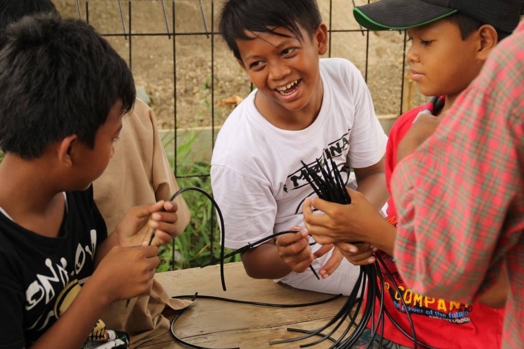Murid menganyam tali bersama teman